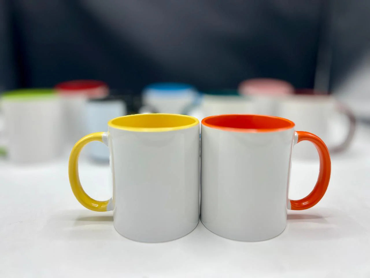 Two mugs with colorful handles on a white surface
