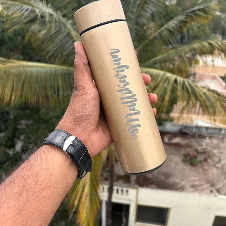Hand holding a beige tumbler with text against a palm tree background