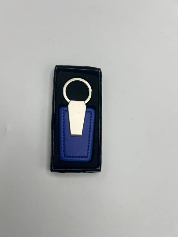 Blue keychain with gold accent in a black box on a gray background